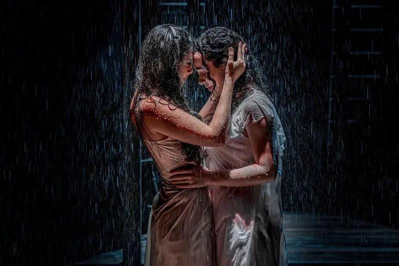Two performers in a rain scene